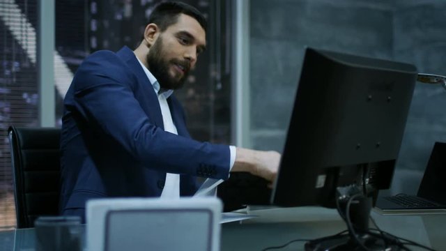 Late at Night Businessman Looses Temper and Hits His Monitor With Keyboard. Shot on RED EPIC-W 8K Helium Cinema Camera.