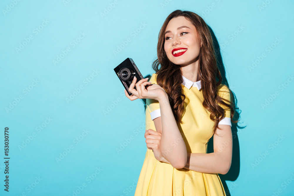 Canvas Prints Beautiful woman in dress holding vintage camera and looking away