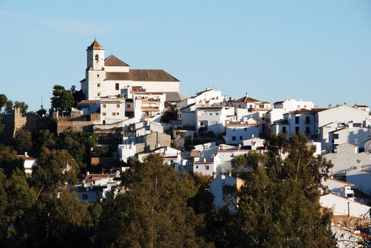 View of the white village with the church at the top, Alozaina, Spain.