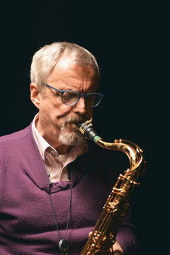 Male playing sax with eyes closed
