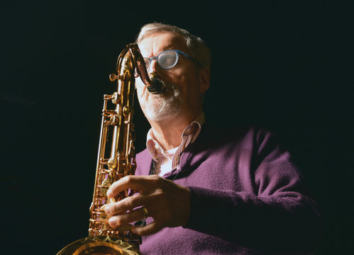 Male playing sax with eyes closed