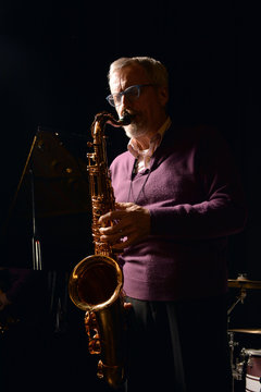 Male playing sax with eyes closed