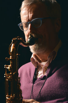 Male playing sax with eyes closed