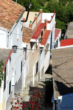 Elevated view of townhouses along a steep village street, Alozaina, Spain.