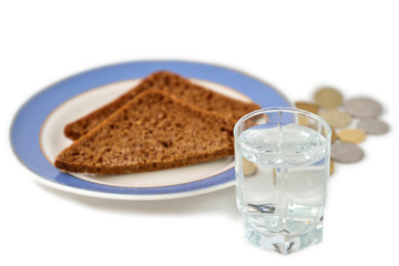 Стопка водки на фоне куска хлеба и металлических монет