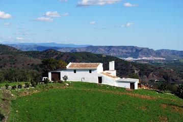 Country house in the Spanish countryside with a white village to the rear, Alozaina, Spain. © arenaphotouk