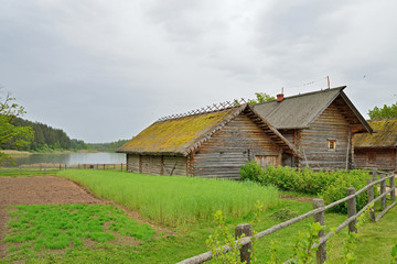 Fototapeta na wymiar The garden and the old Russian log hut in Pushkin Mikhailovskoe