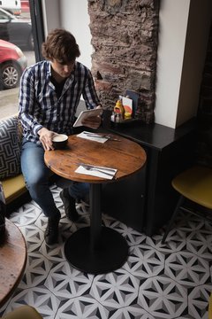 Man using digital tablet while having coffee