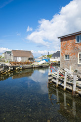 Fototapeta na wymiar Scenic harborside view of the historic fishing village of Peggys Cove, on the maritime coast of Novia Scotia near Halifax, Canada, under bright blue sky