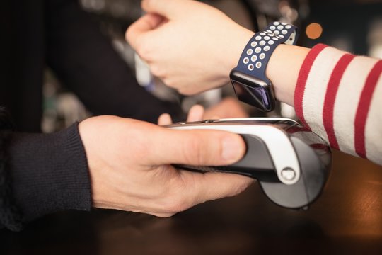 Woman paying through smartwatch using NFC technology