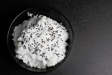 Rice. Plater with rice black sesame over stone table.Copy space