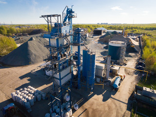 asphalt-concrete plant in the field among the forests. aerial view