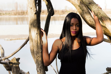 Emerging from the river. Black model in a swimsuit on a sunny day