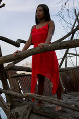 Looking out. Black model in a red dress looking forwards from a vantage point