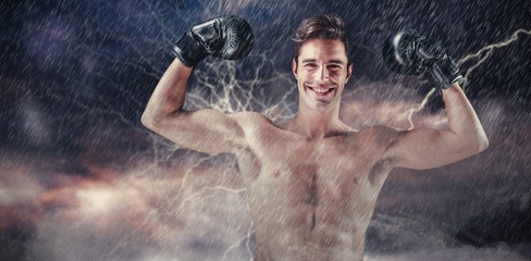 Composite image of portrait of happy boxer showing muscles