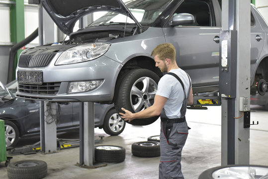 Car mechanic in a workshop changing car tire