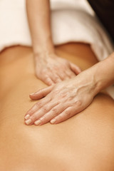 Beautiful woman relaxing receiving body massage at spa center