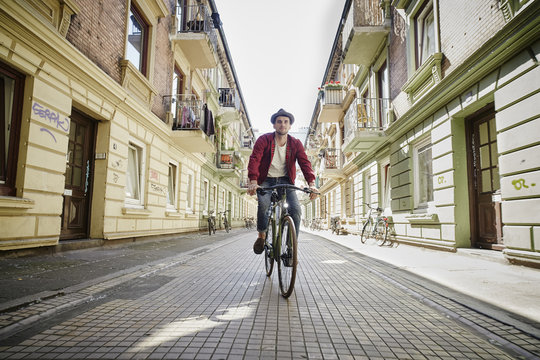 Germany, Hamburg, St. Pauli, Man riding bicycle in he city