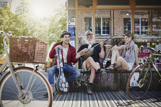 Germany, Hamburg, St. Pauli, Couple listening to old sailor, making street music