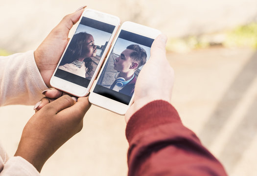 Hands holding smart phones with pictures of a young couple