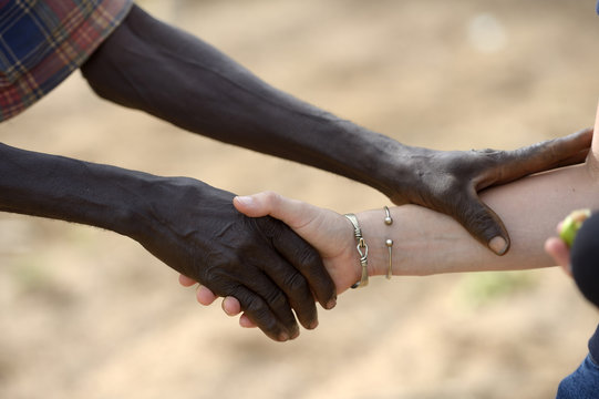 Burkina Faso, old African man shaking hands with white woman