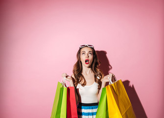 Portrait of a cute excited girl holding colorful shopping bags