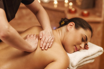 Beautiful woman relaxing receiving body massage at spa center