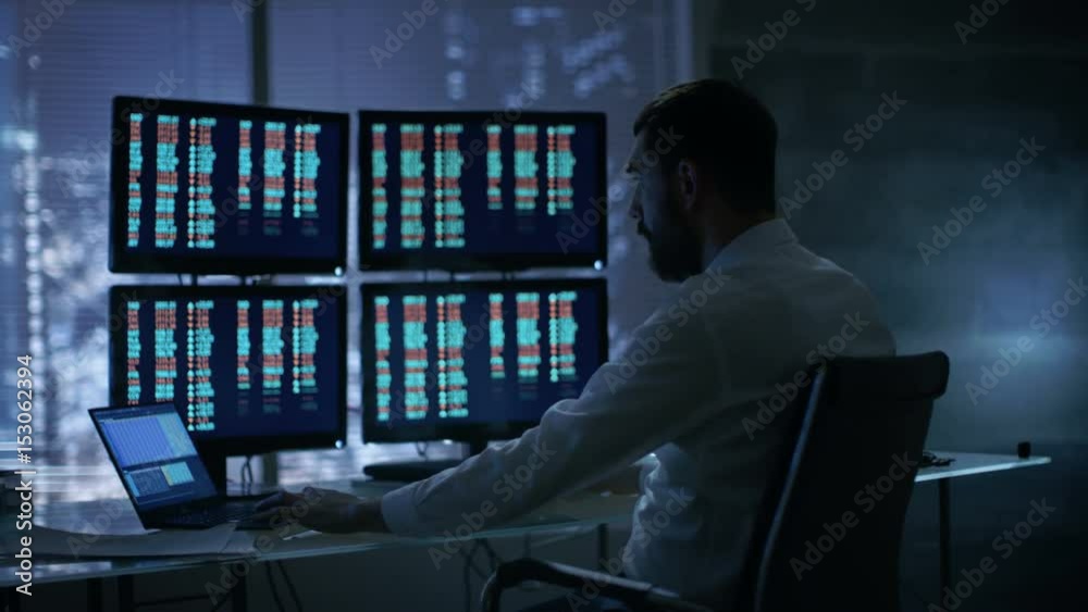 Poster late at night trader reads numbers on his multiple displays with. he succeeded in winning big on sto