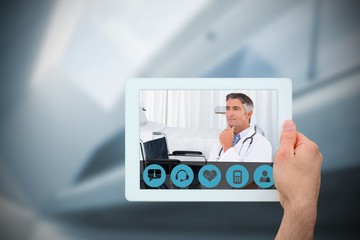 Composite image of hand holding tablet pc