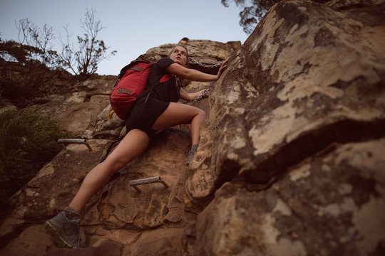 Woman climbing cliff