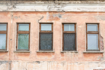 windows on wall of old house with peeling plaster