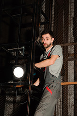 Fototapeta na wymiar The lighting engineer adjusts the lights on stage behind the scenes