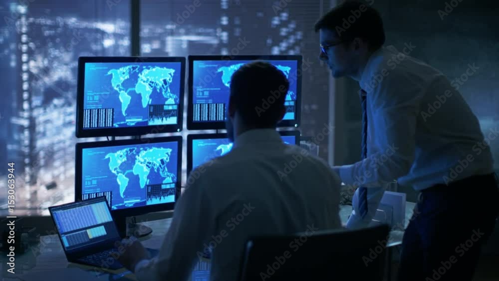 Poster Late at Night in Office Building Security Service Men Have Discussion while  Attentively Observing Monitors with Location Sensitive Information Shown on Them.  Shot on RED EPIC-W 8K Helium Camera
