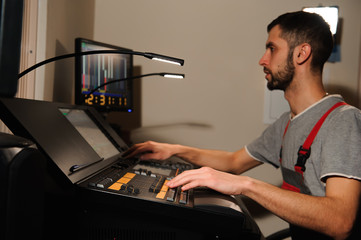 A lighting engineer works with lights technicians control on the concert show. Professional light...