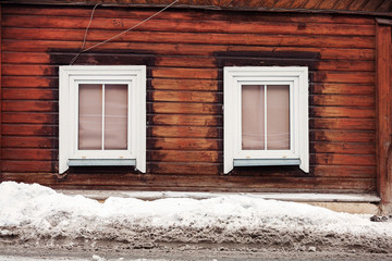 Two windows on a wood plank wall