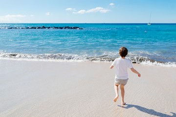 Happy child boy playing on beach