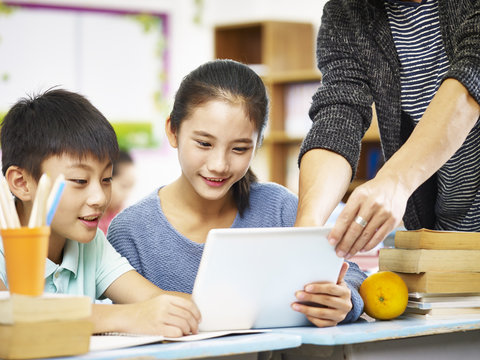 asian elementary schoolchildren using digital tablet in classroom