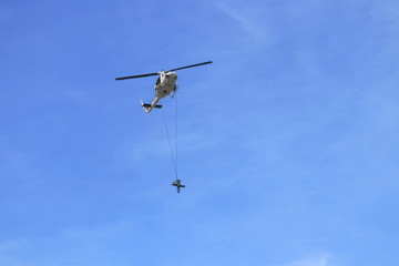 Soldier rescue emergency by army helicopter with rope  on blue sky and  blur propeller