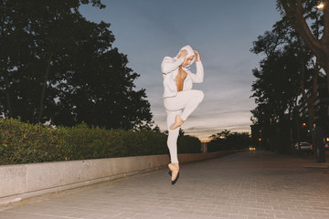 muscle male dancer performing a ballet pose with casual clothes