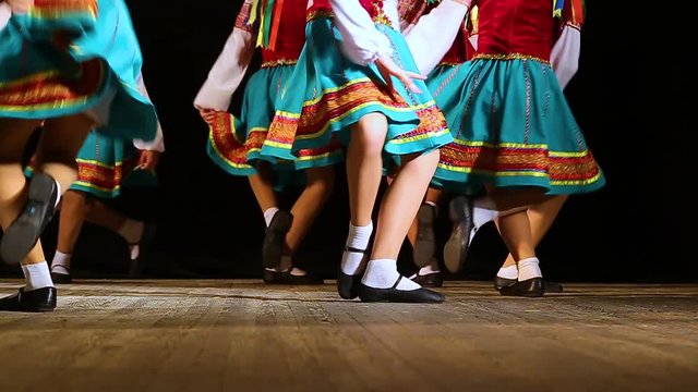 Closeup of young dancers dancing folk dance on stage. Slow motion hd video footage.