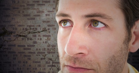 Man's sad face against brown brick wall