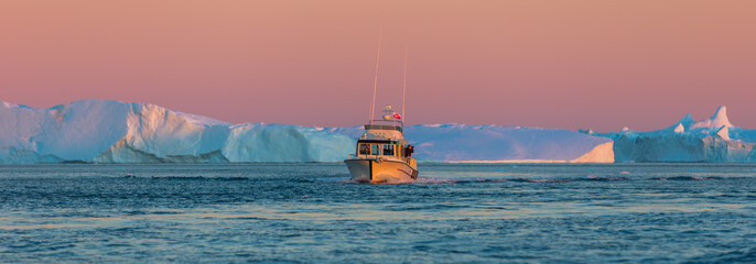 Tourists take pictures of the iceberg. Source of icebergs is by the Jakobshavn glacier. This is a...