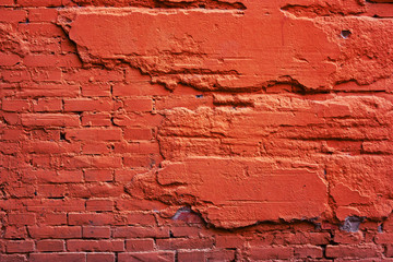 A wall of red brick, and a destroyed cement.