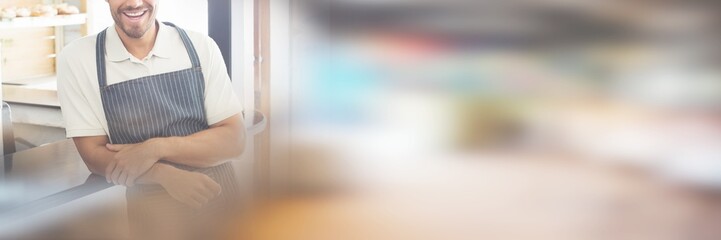 Portrait of smiling young waiter at cafe counter