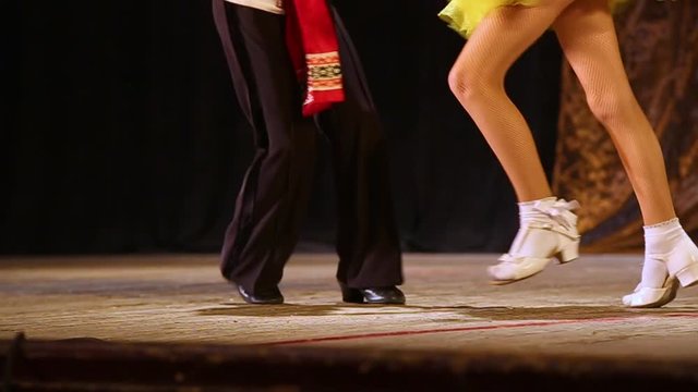Young couple of dancers dancing on stage. Closeup of kid's male and female legs. Slow motion hd video footage.
