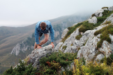 Naklejka premium Young white man is climbing a stone