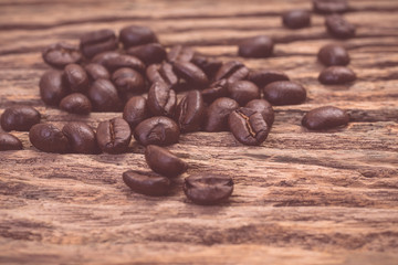 Roasted coffee beans on wood texture background. vintage color effected
