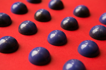 Handmade chocolate hemisphere on a red background. blank candy . selective focus