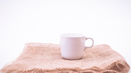 Fototapeta na wymiar White Coffee mug and sack on white background. vintage color effected