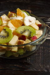Fruit desserts made at home. Plate with sliced fruit. Fresh fruits on a wooden background.